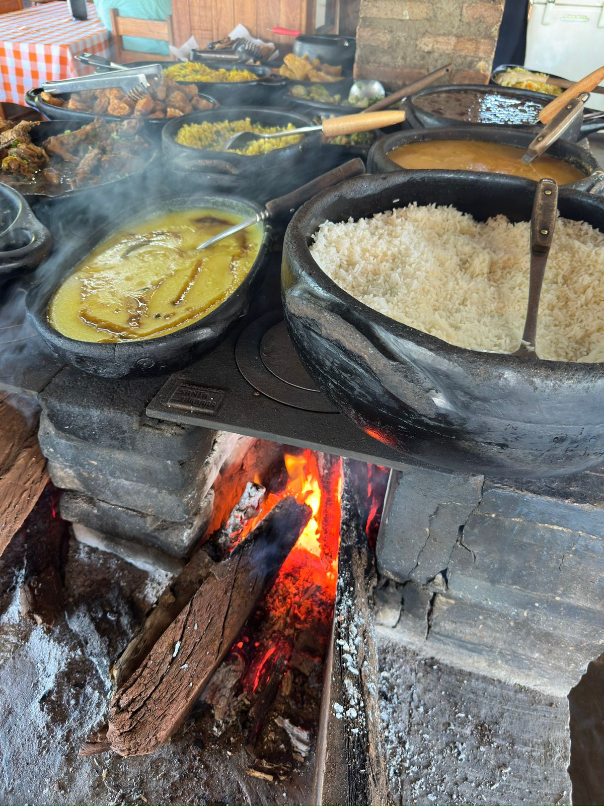 Panelas de barro com comida caipira no fogão a lenha